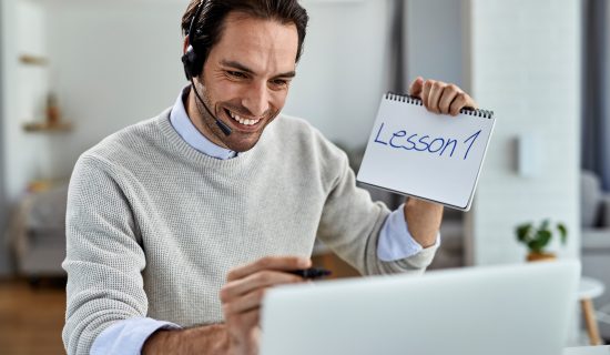 A man holding up a piece of paper with the word lesson 1 written on it.