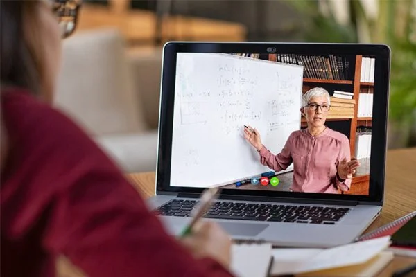 A person is sitting at a table with a laptop.