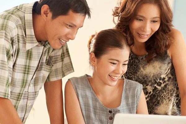 Three people looking at a laptop screen